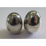 A pair of silver egg shaped peppers