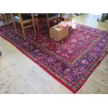 A Heriz style carpet, the red ground with all over palmette design and dark blue border, 306cm x