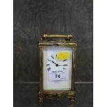 An Edwardian brass carriage clock, with shaped case, the enamel dial inscribed Stewart & Co, 15cm