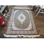 A Persian silk rug, the green ground with all over floral design and central ivory medallion