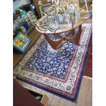 A Cashmere rug, the blue ground with central ivory medallion and all over scroll design within an