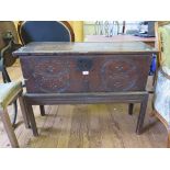 A 17th century planked oak coffer, with twin roundel carved front, on a later stand 97cm wide,