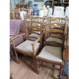 A set of four stained wood ladderback dining chairs, including one carver, with turned and block