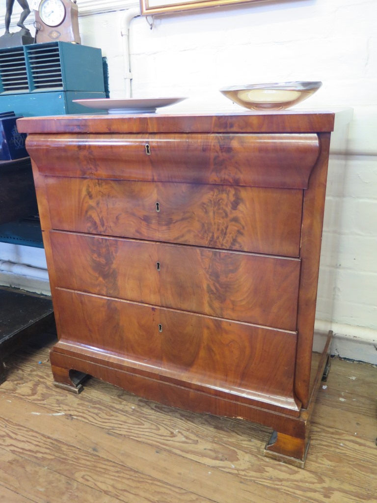 A 19th century Beidermeier flame mahogany chest of drawers, the moulded top drawer over three