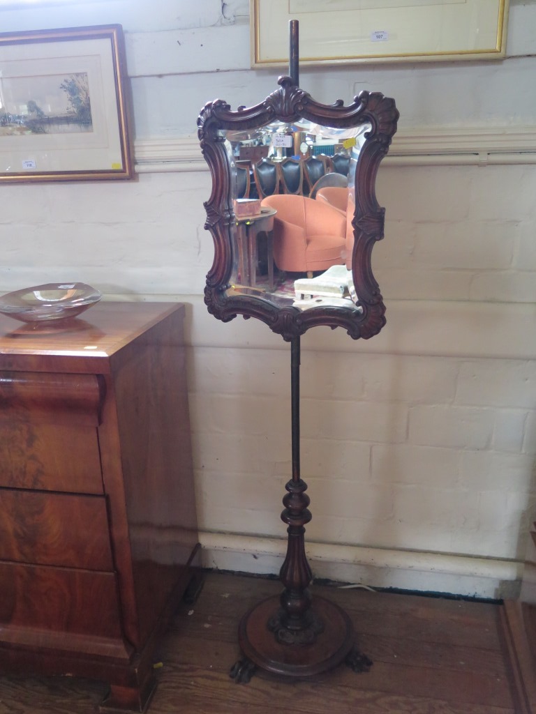 A mid Victorian walnut pole screen, the scrolling mirrored screen on a lobed balister stem, with