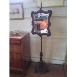 A mid Victorian walnut pole screen, the scrolling mirrored screen on a lobed balister stem, with