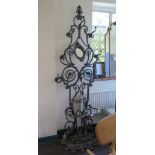 A Victorian style cast iron hall stand, of floral scroll form with hinged oval mirror and umbrella