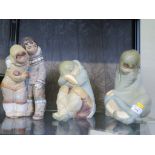 A Lladro figure of two Eskimo children 33cm high, and two others of sleeping Eskimos 25cm and 30cm