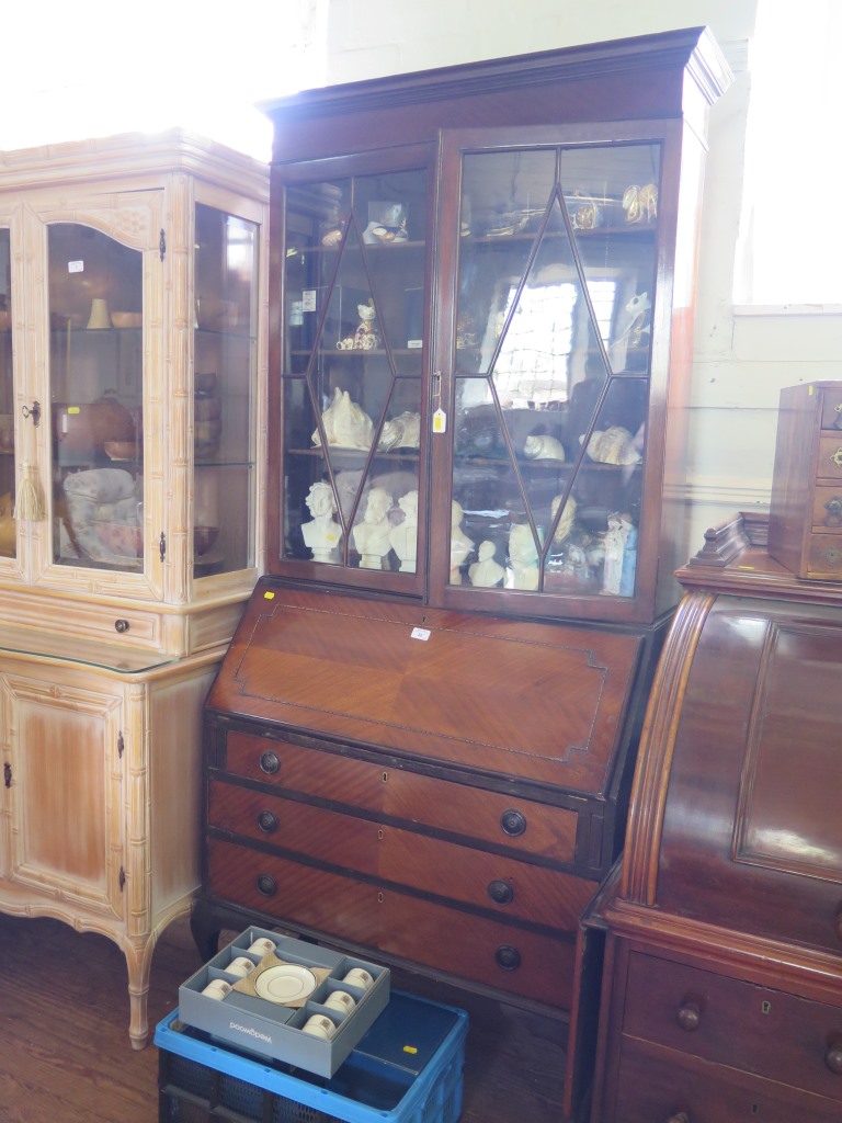 A 1920's mahogany bureau bookcase, the glazed top over a sloping fall with fitted interior over