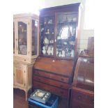 A 1920's mahogany bureau bookcase, the glazed top over a sloping fall with fitted interior over