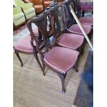 A set of six Edwardian mahogany dining chairs, with outsplayed pierced and rosette carved splats