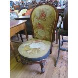 A Victorian walnut nursing chair with scroll carved top rail, original bird and floral tapestry
