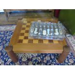 A teak backgammon and chess table with resin Napoleonic chess pieces, 60cm square x 26cm high