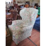 A George III style upholstered wing armchair on cabriole legs and club feet