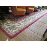 An Indian wool carpet, the red ground with all over foliate and floral design within an ivory