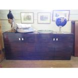 A faux rosewood sideboard, of rectangular form with two pairs of cupboard doors enclosing glass