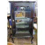 A Victorian ebonised music cabinet, with shaped glazed door and velvet lined shelves on cabriole