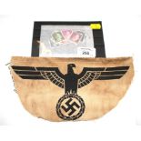 A Third Reich cloth eagle badge and a set of stamps
