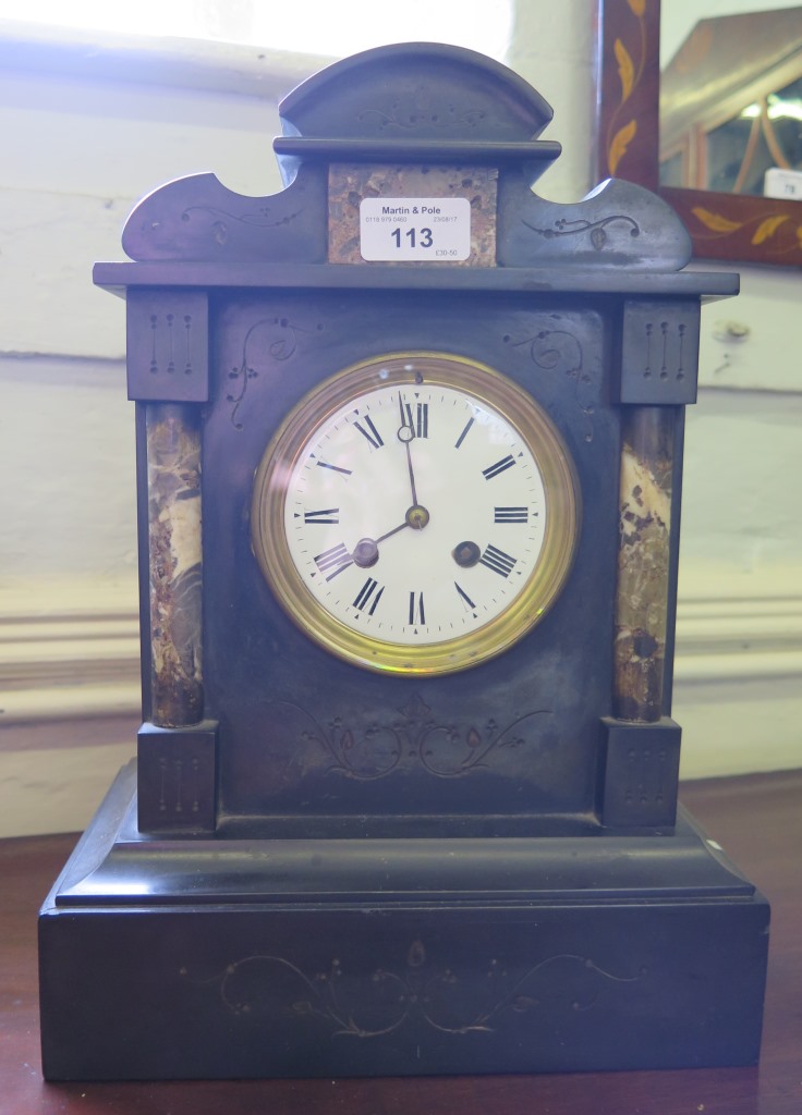 A Victorian black slate and marble mantel clock with shaped top and foliate scroll engraving, the