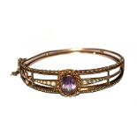 A 9 carat gold bangle, set with centre amethyst and seed pearls