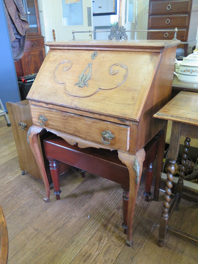 A French walnut bureau, with metal gallery, scroll carved sloping fall and frieze drawer on cabriole