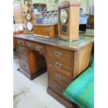 An Edwardian walnut kneehole desk, the leather inset top over a central drawer flanked by four