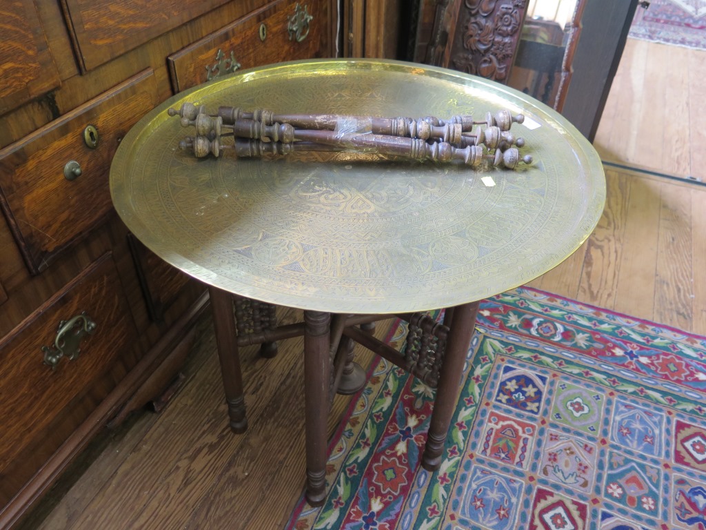 A Middle Eastern brass top circular table, on folding turned stand, 68cm wide