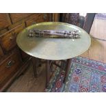 A Middle Eastern brass top circular table, on folding turned stand, 68cm wide