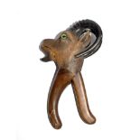 An early 20th century Black Forest nutcracker in the form of a ram's head with original glass eyes