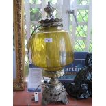 A brass oil lamp of leaf and cabochon design with yellow glass shade, 61cm high