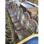 A set of six stained beech hoop back chairs, with carved rails, leather seats and turned legs joined