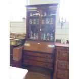 A 1920's mahogany bureau bookcase, the glazed top over a sloping fall with fitted interior over