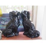 A pair of Staffordshire black glaze seated dogs, with gilt highlights, 35cm high