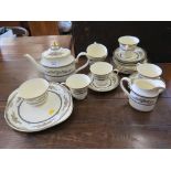A Minton satinwood pattern tea service with six place settings, milk jug and teapot