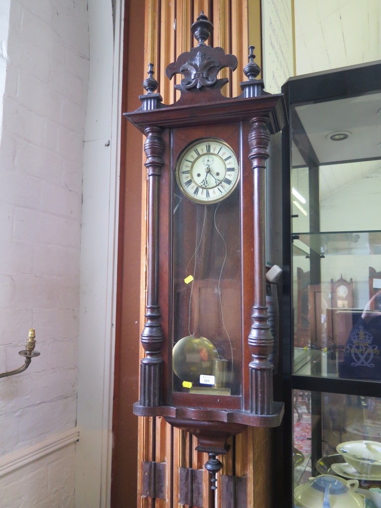 A stained wood Vienna style wall clock, with turned finial surmount, twin train movement striking on