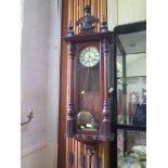 A stained wood Vienna style wall clock, with turned finial surmount, twin train movement striking on