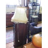 A wrought iron adjustable standard lamp, converted to electricity, with adjustable stem and