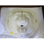 A white marble water tap surround, in the form of a lion mask, 36cm wide, 30cm high