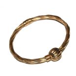 A gold colour sprung loaded bangle (with dent)