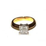 An 18 carat gold ring set with four princess cut diamonds in a square