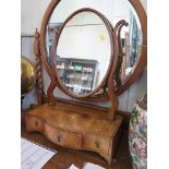 A George III crossbanded mahogany toilet mirror, the oval plate above three serpentine drawers on
