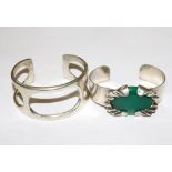 Two silver bangles one set with a green stone