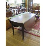 A large George III mahogany dropleaf table, the oval top on turned legs and club feet, in need of