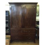 A George III mahogany linen press, the dentil cornice over a pair of panelled doors, enclosing