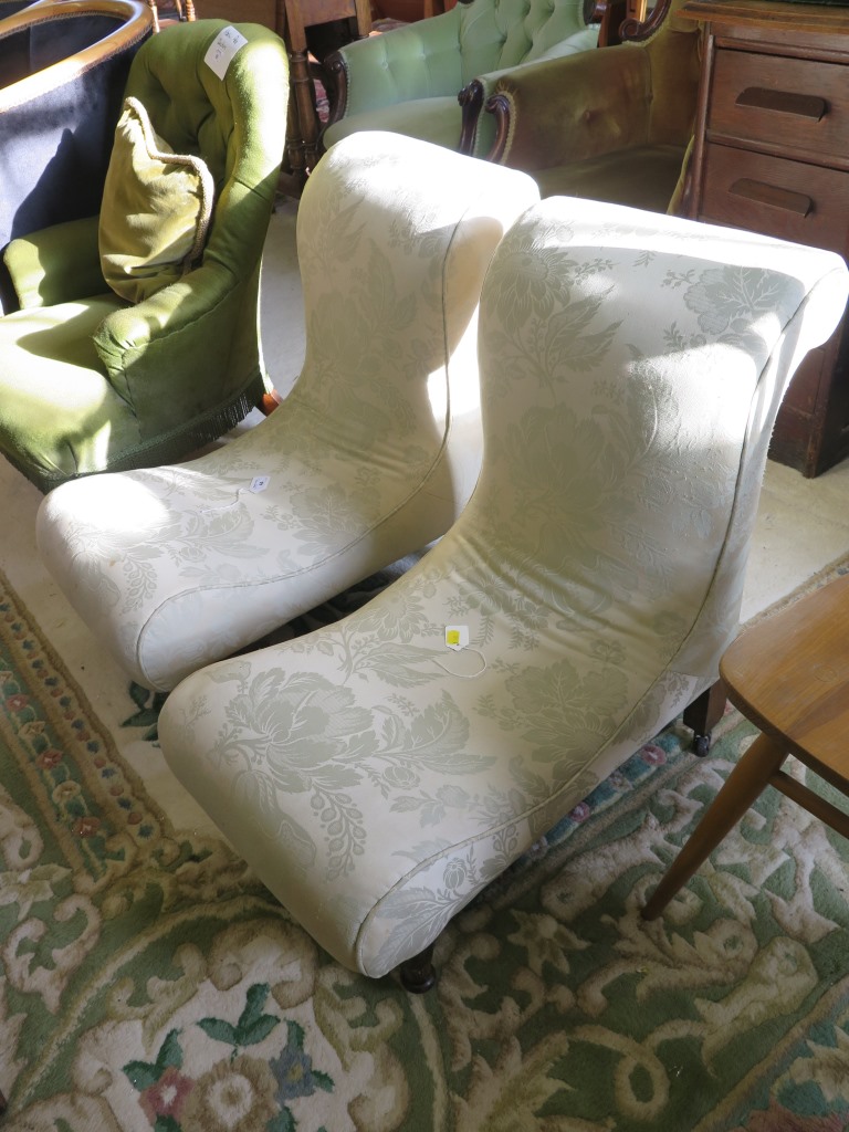 A pair of Victorian upholstered low nursing chairs, with scroll back and seat on turned legs and