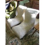 A pair of Victorian upholstered low nursing chairs, with scroll back and seat on turned legs and