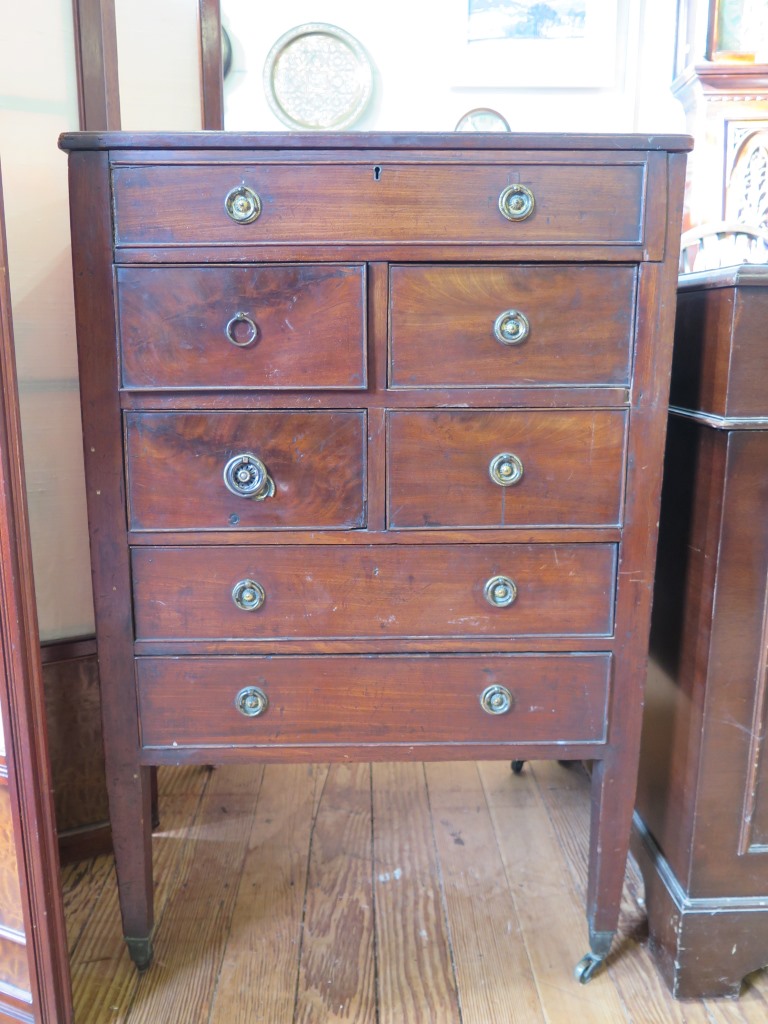 A George III mahogany cabinet, the hinged glass bijouterie top over a dummy drawer, four short and