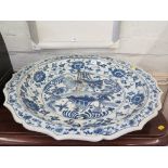 A large Chinese blue and white charger of barbed fish design, with floral shaped border 66cm