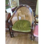A Regency mahogany Bergere chair, with reeded downswept arms and canework back over a loose