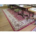 An Indian wool carpet, the red ground with all over foliate and floral design within an ivory